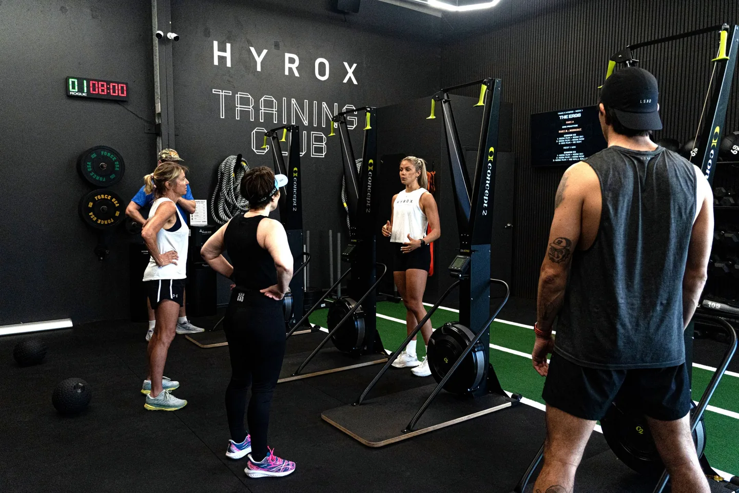 Dedicated HYROX training environment with athletes, SkiErgs, and coach education