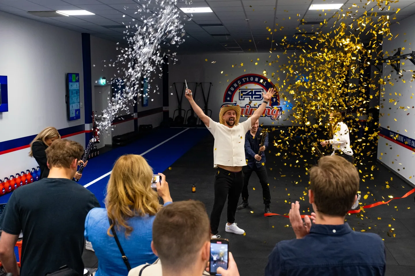 A gym launch event with confetti and a crowd
