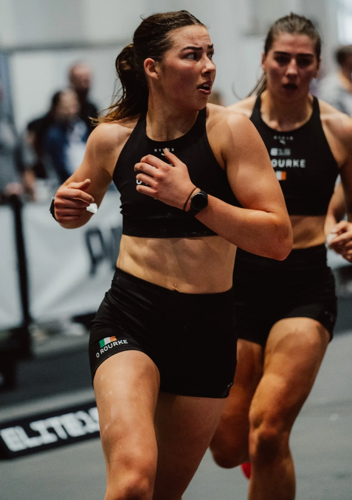 Female HYROX athletes running during a competition