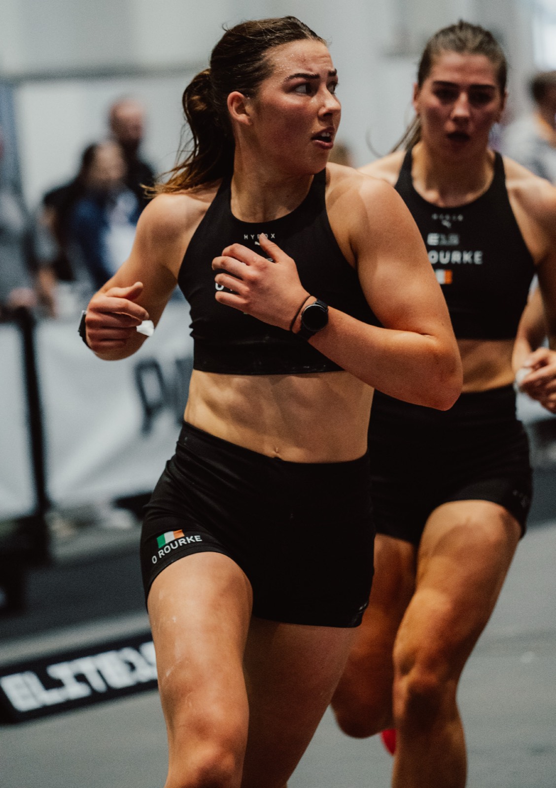 Female HYROX athletes running during a competition