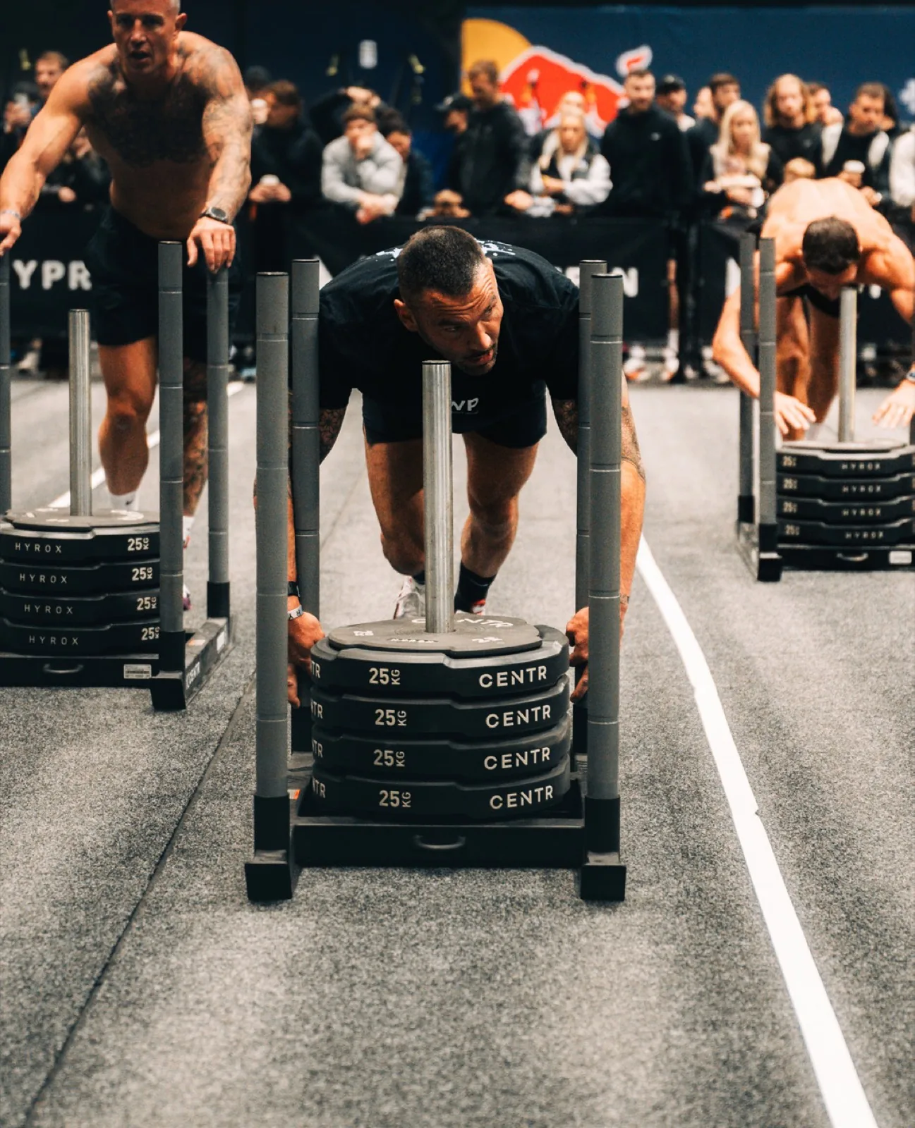Athlete driving a loaded sled push at a HYROX race