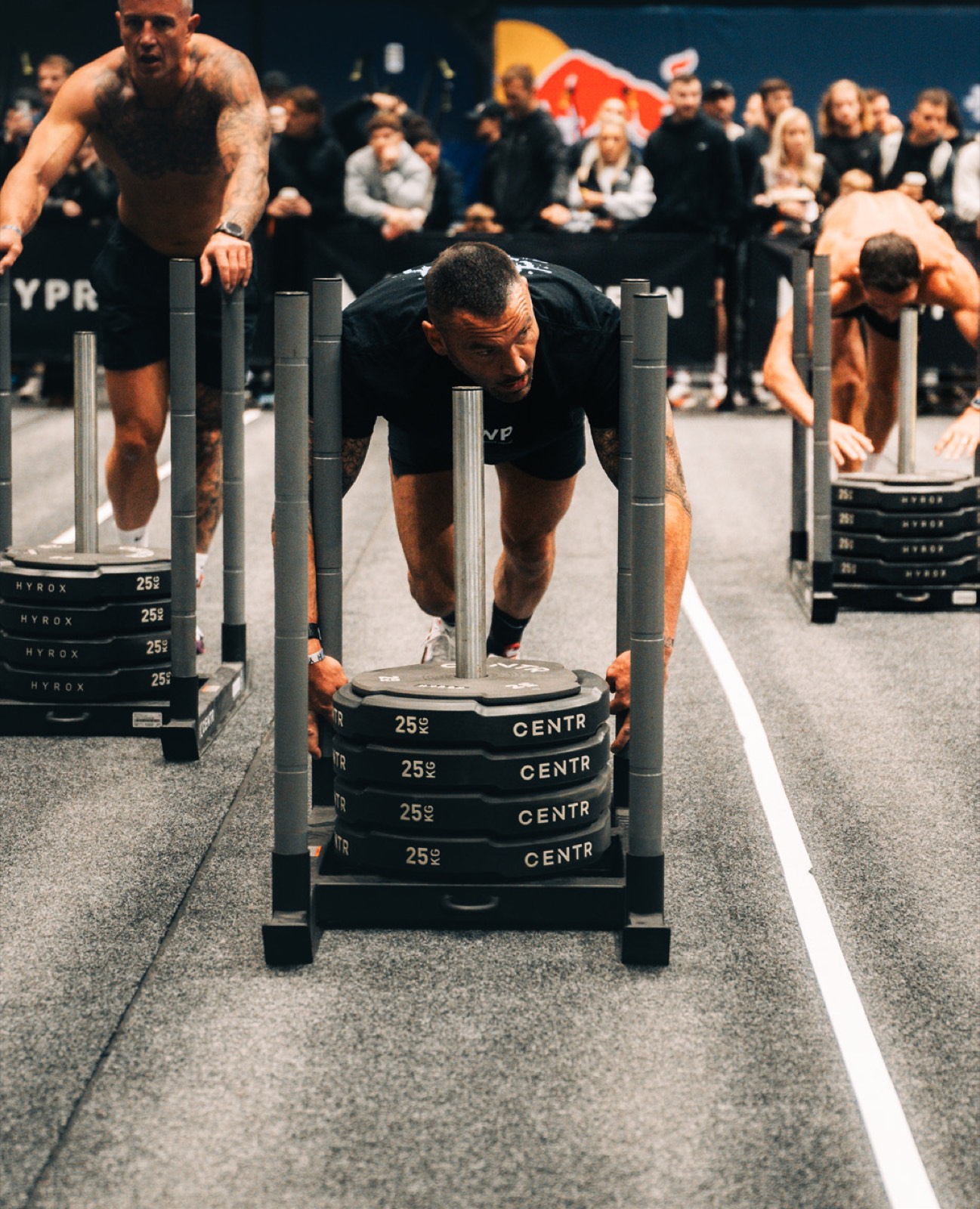 Athlete driving a loaded sled push at a HYROX race
